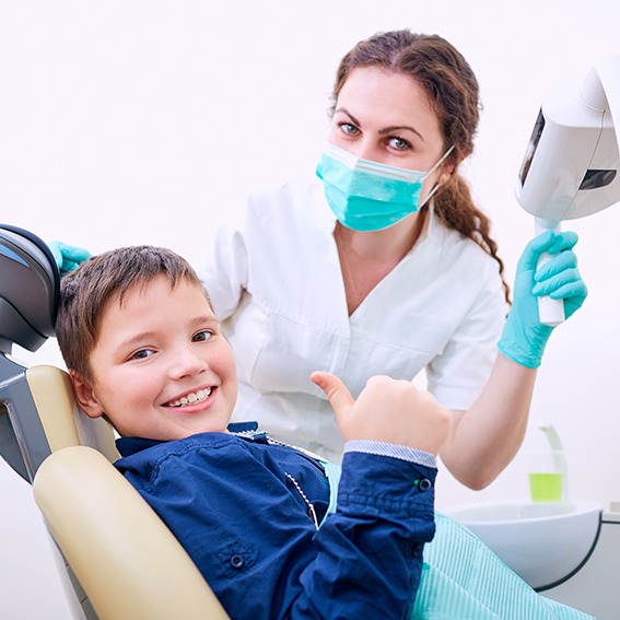 Child receiving dental checkup and smiling