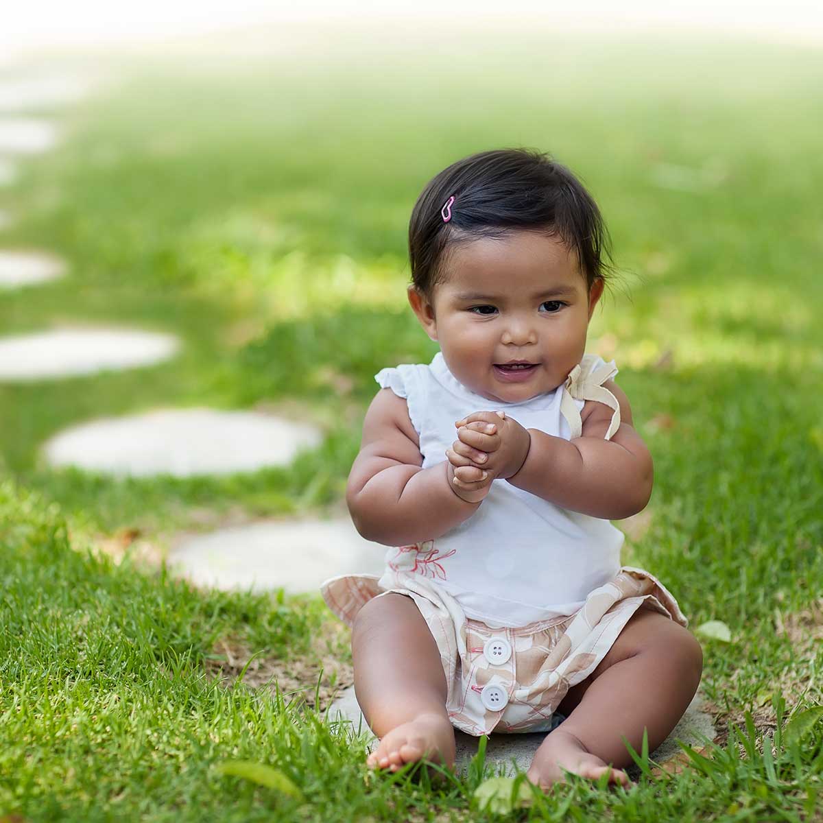 Baby sitting in grass after age one dental home visit in East Cobb