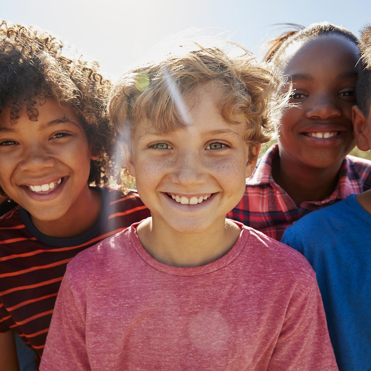 Group of kids smiling outdoors after seeing pediatric emergency dentist in East Cobb