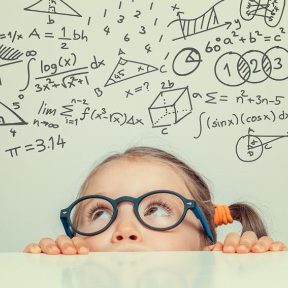 Child with glasses looking up at illustrations of mathematical figures 