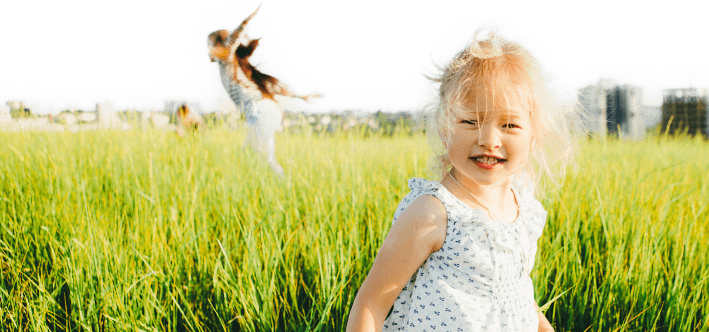 Young girl smiling while sitting in grass