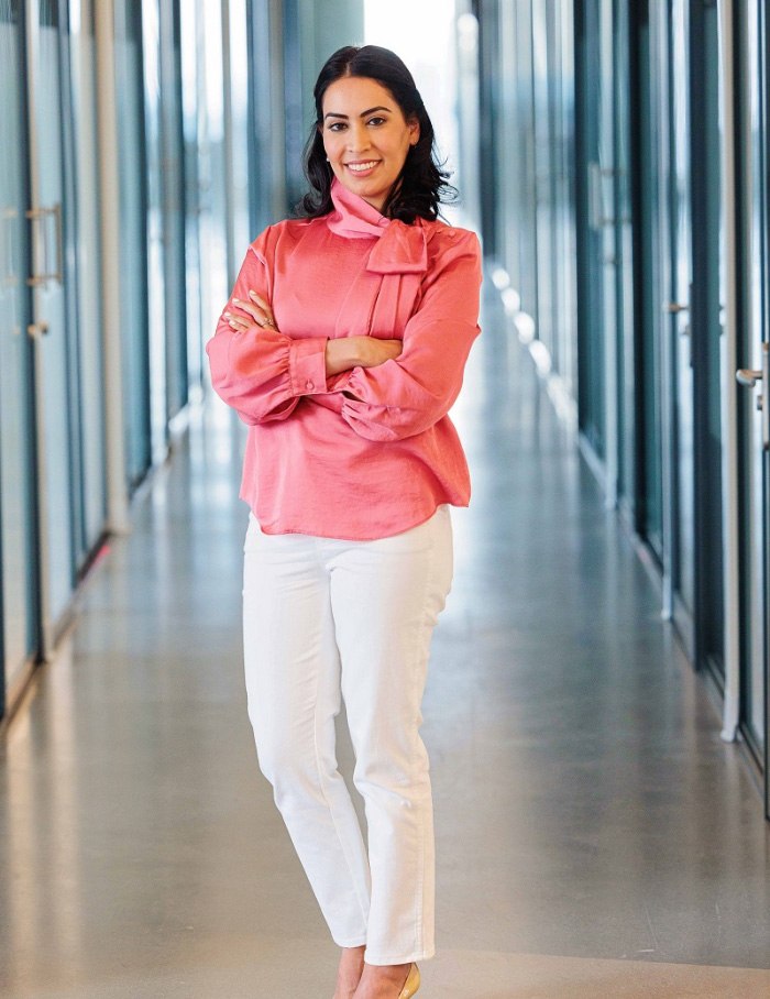 East Cobb pediatric dentist Doctor Sheh Vahid standing in hallway smiling with arms crossed