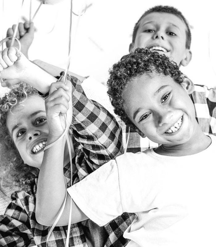 Black and white photo of a smiling group of kids