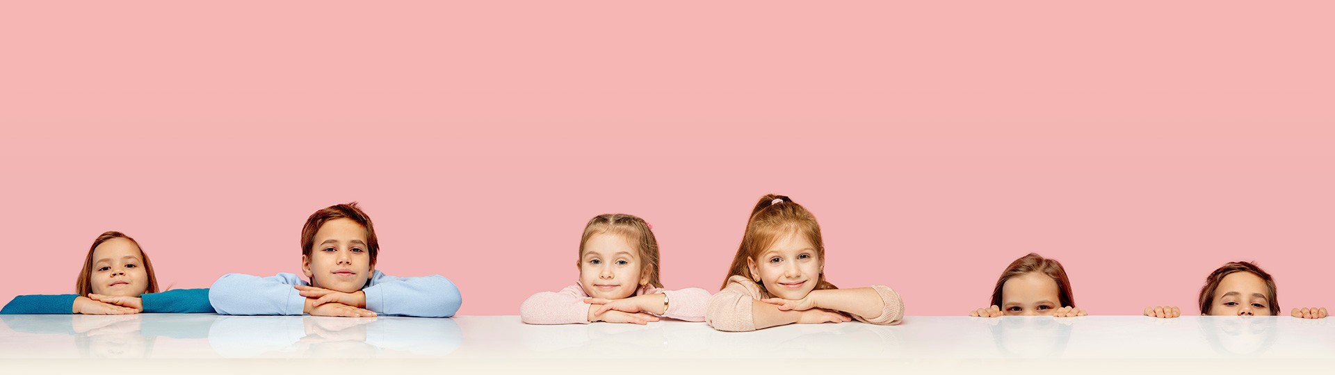 Group of kids resting their heads on their crossed arms at countertop