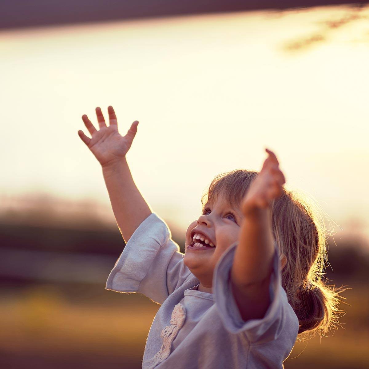 Young child reaching her arms up after children's preventive dentistry visit in East Cobb