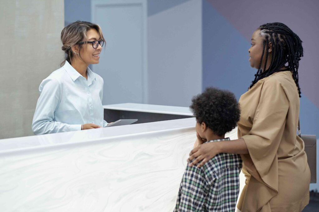 Mother and son talking to a receptionist